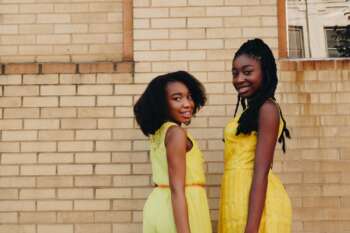 Two girls wearing bright yellow dresses